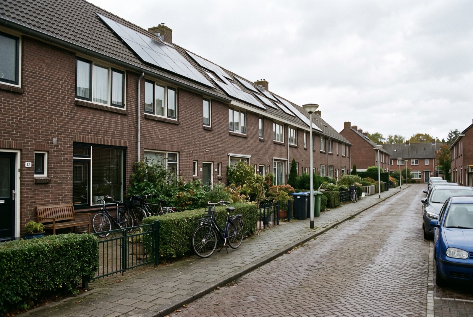 Rij bakstenen eengezinswoningen met zonnepanelen op het dak in een Nederlandse woonwijk